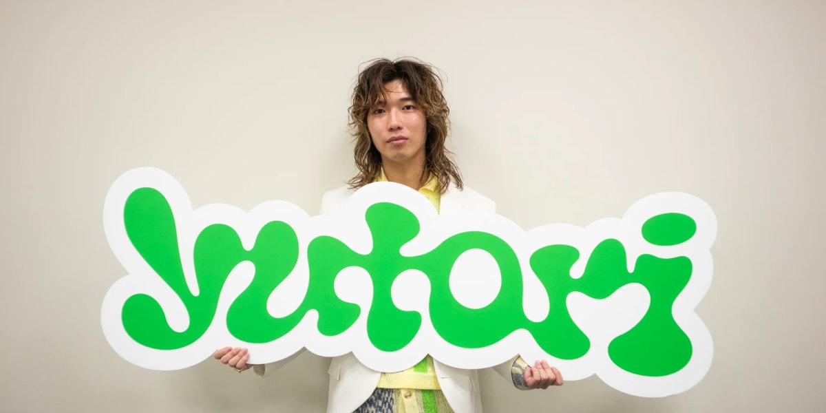 yutoriのロゴパネルを持った片石貴展代表
