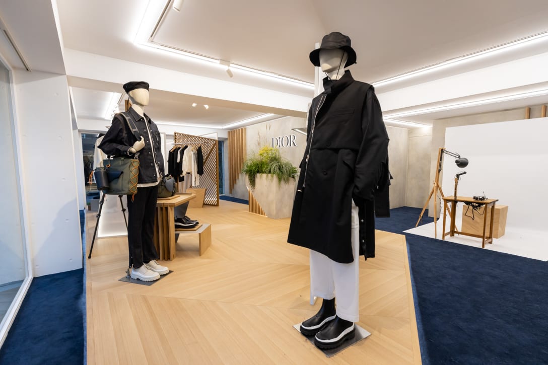 アシンメトリカルな空間設計が特徴の店内。カーペットは今回のカプセルコレクションを象徴するネイビーブルー。ヘリンボーンの床は、パリにあるディオール本店のタイムレスなエレガンスを想起させる。